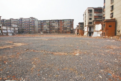 為降塵，旮旯王村拆遷后裸露的地面上鋪了一層石子。