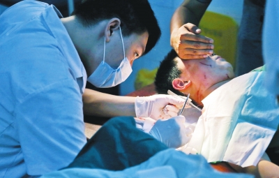 孩子身上有7道傷痕，其中兩道需要縫合，其他的均為擦傷，醫(yī)生正對(duì)他施治。