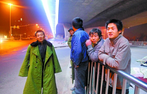 冬夜里，農(nóng)民工在橋下等著干活兒。