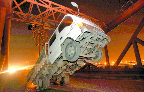 　車上升降機的工作臺被卡，車身前部高高翹起。