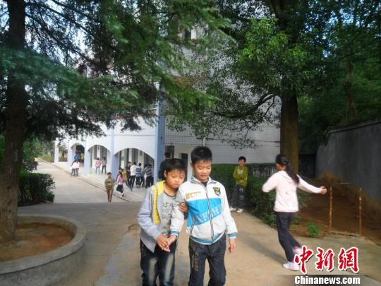 4年來，13歲的余興泉（左一）每天都攙扶著腿腳不便的同學(xué)左臣進(jìn)出教室、食堂和廁所。 李俊杰 攝