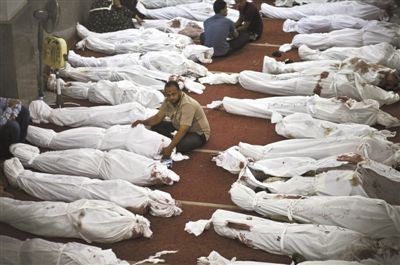 8月15日，在埃及首都開羅的一個清真寺，人們在成排的遺體旁哀悼。