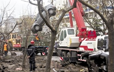 輸油管道爆炸后，搶修人員將被炸毀的車輛運(yùn)出現(xiàn)場(chǎng)。