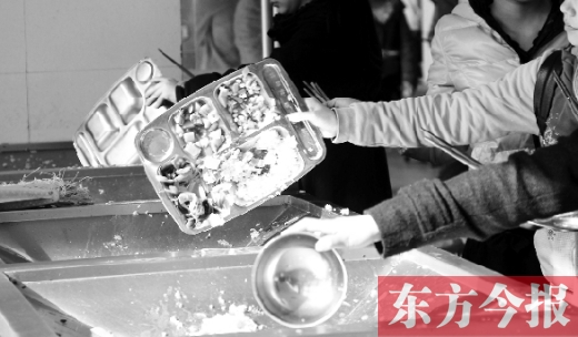 11月27日，河南中醫(yī)學(xué)院餐廳，一名同學(xué)將餐盤內(nèi)沒吃完的食物倒入餐具回收車內(nèi)