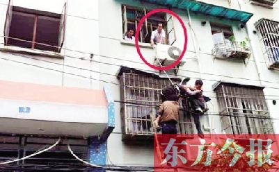 施救現(xiàn)場(chǎng)，劉鵬（圈內(nèi)）先用繩子捆住老太確保安全 勞動(dòng)報(bào)記者 郭娜 供圖