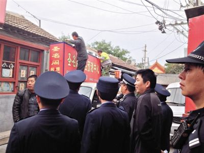 昨日下午,東城區(qū)工商、城管、公安等部門(mén),對(duì)雍和宮附近的預(yù)測(cè)中心進(jìn)行清理整頓,站在車頂?shù)膬擅と苏鸪患摇邦A(yù)測(cè)中心”的招牌。因雍和宮、白云觀等文化景點(diǎn)外聚集大量算命先生,被媒體稱為“算命一條街”。本版攝影/新京報(bào)記者 李寧 攝