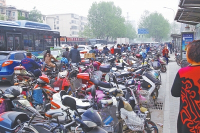 省人民醫(yī)院北門，路邊的公交站牌處停滿非機動車，上、下客只能在快車道上。