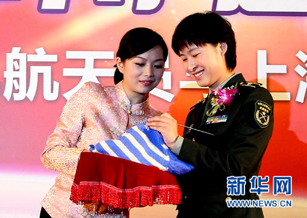 11月1日，航天員劉洋（右）在為“愛心”毛衣編織最后的收尾針。