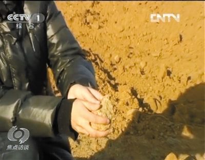 麻剛沙系麻剛石粉碎而成。記者找到一塊麻剛石，一捏就碎成粉末，硬度非常差。央視截圖