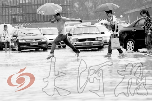 鄭州經(jīng)三路與北環(huán)交叉口處，積水較深，行人們不得不“練輕功”。 記者 白周峰 攝影
