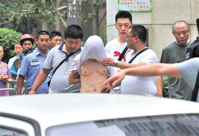 昨日，成都警方抓捕時與毒犯發(fā)生槍戰(zhàn)。一名男犯罪嫌疑人被警方押出。