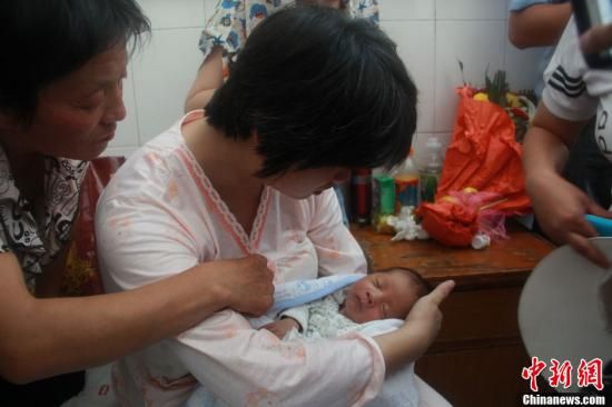 圖為陜西富平“產(chǎn)科醫(yī)生拐賣嬰兒”一案中的被拐嬰兒于8月5日中午在該縣婦幼保健院由當(dāng)?shù)鼐浇挥谄涓改?。張一?攝