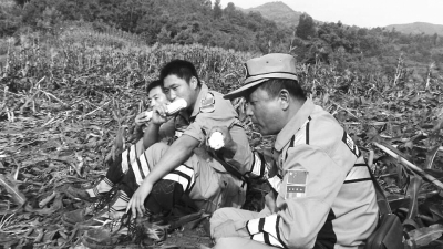 饑餓難忍，中國(guó)緊急救援河南基地的救援隊(duì)員在已毀的玉米地里撿拾生玉米吃。