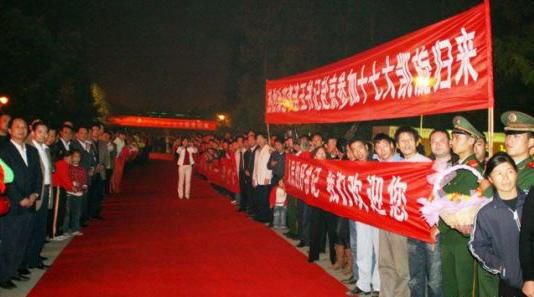 “夾道歡迎”中不少人打出橫幅，路上被鋪上了紅毯。
