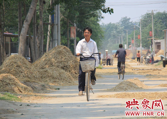 圖為王格現(xiàn)騎著自行車(chē)去學(xué)校。