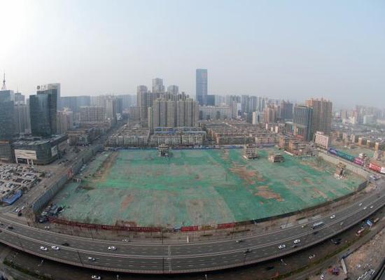 2016年4月，經(jīng)過持續(xù)攻堅，親賢社區(qū)西北片區(qū)的拆遷工作基本告一段落，但在鋪設(shè)了防塵綠網(wǎng)的空地中，至今仍有3戶居民選擇了“堅守”。(拍攝：2016年4月4日)