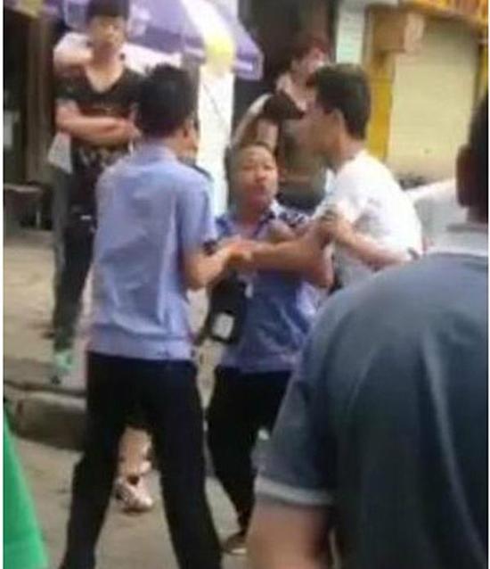 付某（右）與城管執(zhí)法人員廝打在一起。