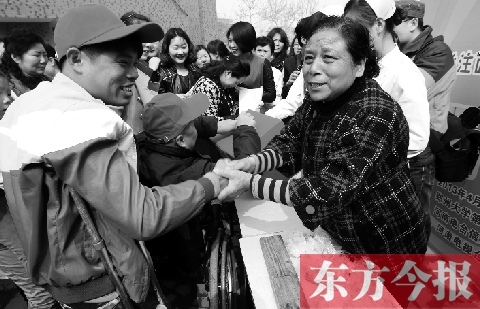 昨日，鄭大四附院的大樓前，“面人鄭”鄭玉芬（右）向前來(lái)捐款的殘疾人表示感謝