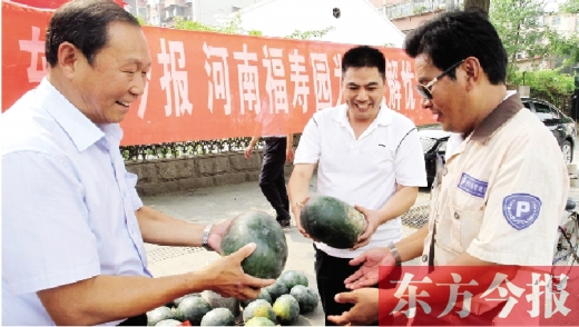 河南福壽園區(qū)域總經(jīng)理吳正宗（左一）、東方今報(bào)發(fā)行中心副總監(jiān)王路喜（中）在街頭給市民送瓜