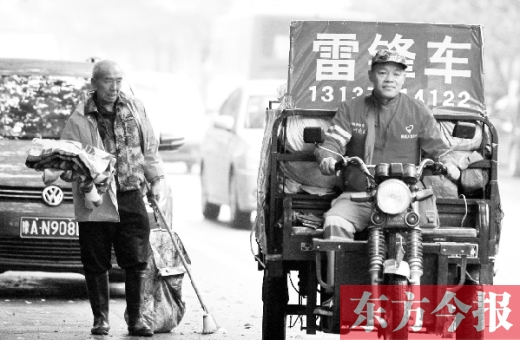 鄭州市商城路，一名環(huán)衛(wèi)工懷抱著剛剛收到的毯子，目送“雷鋒哥”孫德坤離開