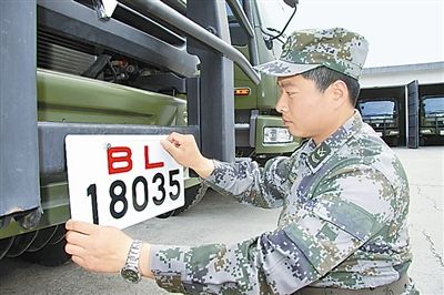 駐京某部上士高振超正在認(rèn)真更換新式軍車號牌。　　　本報記者　尹　航攝