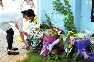 6月8日下午，記者來到廈門公交車爆炸事發(fā)現(xiàn)場橋下，附近已聚集了十幾個自發(fā)前來悼念的市民。橋墩下排放了一圈或黃或白的菊花，還有玖瑰、百合等。