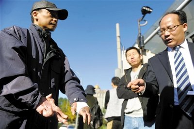 常林鋒在法院外展示雙手，他稱被燙傷的手因刑訊逼供且未得到及時(shí)救治