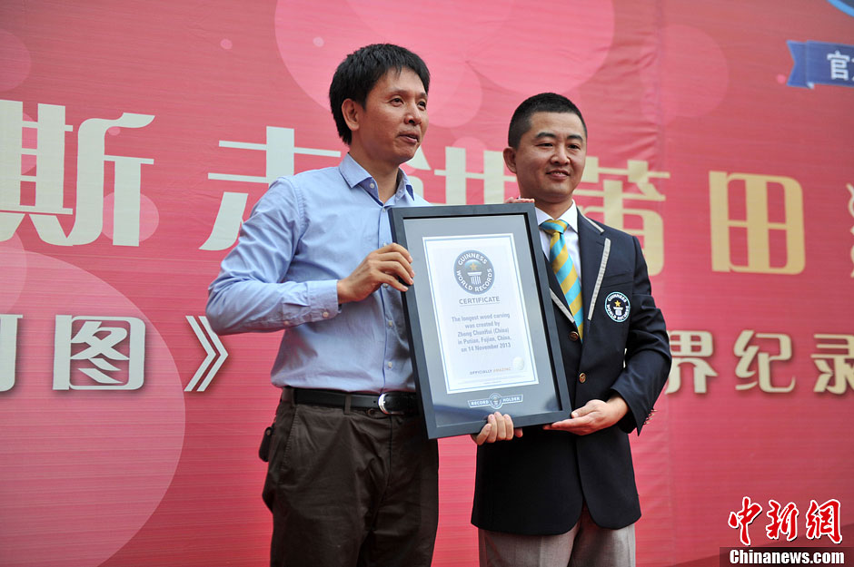 圖為世界吉尼斯認(rèn)證官為鄭春輝（左）頒發(fā)證書(shū)。呂明 攝