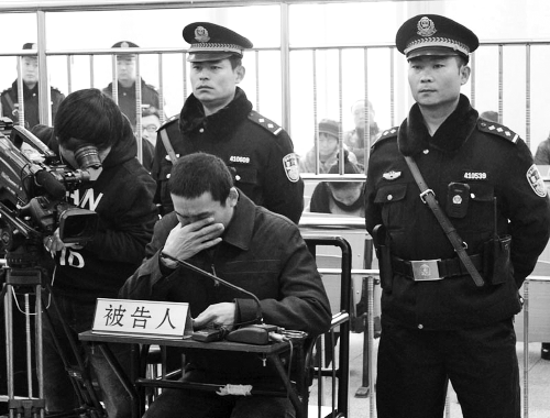 庭審中,29歲的李軍低著頭。