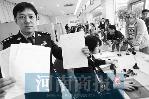 　民警左手拿的是新申請(qǐng)表，右手拿的是三份老申請(qǐng)表 王春勝/攝