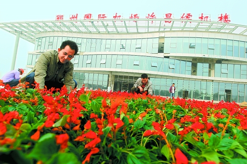 9月23日，工人們正在鄭州國際機(jī)場許昌候機(jī)樓前擺放鮮花。