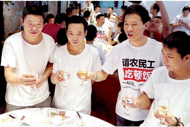 活動(dòng)發(fā)起人張楠（右二）給農(nóng)民工敬酒。