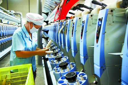 7月3日，在鄧州市永泰棉紡有限公司電腦控制全自動紡紗車間，紡織工人正在生產(chǎn)棉紗。