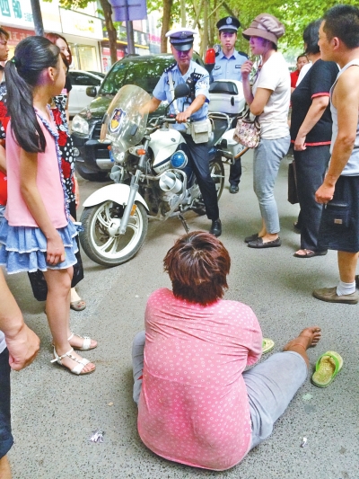 在鄭州優(yōu)勝南路東三街交叉口向東100米處，一名短發(fā)中年女子平躺在路南快車道上，身旁還有一只掉落的拖鞋
