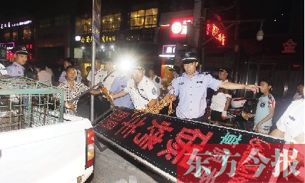 7月8日晚，鄭州市商城路一家占道經(jīng)營(yíng)的攤販招牌被執(zhí)法隊(duì)員“登記保存”