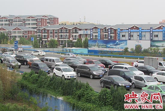 記者看到鄭州機(jī)場(chǎng)收費(fèi)站口車輛排隊(duì)，與此形成鮮明對(duì)比的是，路的對(duì)面（另一半幅）卻車輛較少，通行順暢。