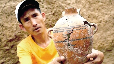 　　考古工作人員展示出土的仰韶文化時(shí)期代表性彩陶。