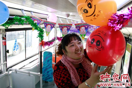 鄭州快速公交B3區(qū)間線車長李鵬云在車廂里懸掛氣球，布置圣誕車廂，營造歡樂圣誕氛圍
