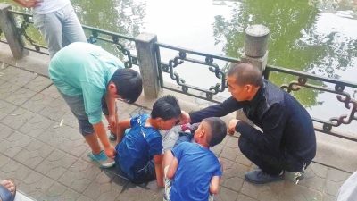 男孩被救出后，圍觀群眾幫他控水換衣服。