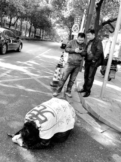 兩名接訪人員與患有癌癥的訪民段新德合影時(shí)，在拍照時(shí)查看手機(jī)。