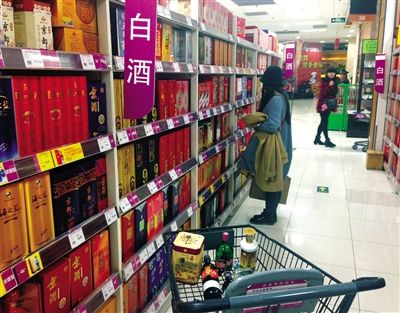 顧客在商場(chǎng)的高檔白酒貨架前駐足挑選。春節(jié)臨近，受“禁令”影響，以高檔白酒為代表的節(jié)日禮品市場(chǎng)面臨考驗(yàn)。記者 王遠(yuǎn)征 攝