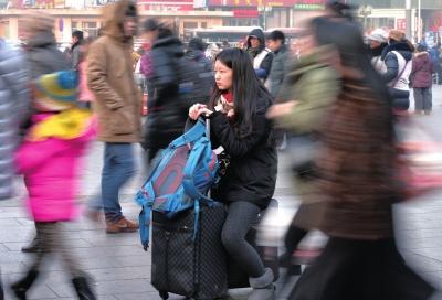 春運(yùn)首日，北京站客流量明顯增多，一名女孩在人流中等待進(jìn)站。
