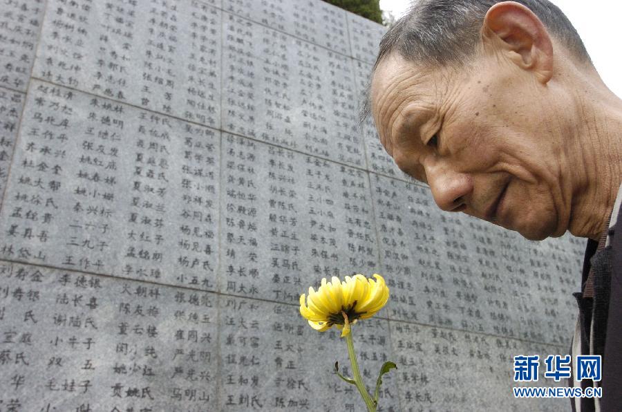 2006年4月5日，74歲的南京大屠殺幸存者佘子清手捧鮮花，祭奠被日軍殺害的母親。