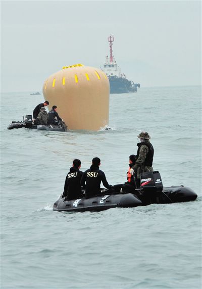 18日，搜救人員準備將氣囊捆綁到沉沒客輪上。