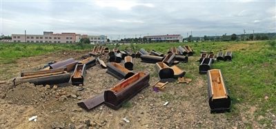 40多副棺木被砸壞后，扔在荒地上。