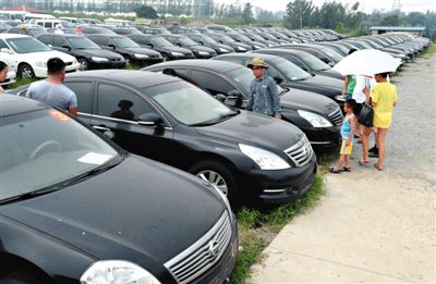 昨日，市民在山東棗莊一家拍賣公司場地上查看待拍賣公車。當日，棗莊市103輛公車公開拍賣。新華社記者