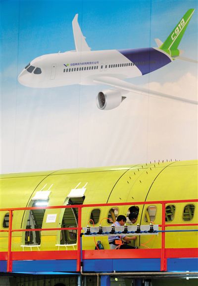 昨日，中國商飛總裝制造中心技術(shù)人員對接C919首架機(jī)的機(jī)體。新華社記者 丁汀 攝