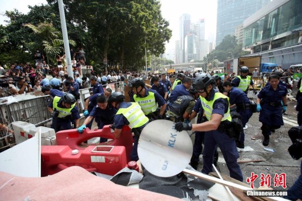 10月14日，警方清除金鐘道障礙物。大批警員在金鐘道現(xiàn)場(chǎng)清拆障礙物。部分警員戴上頭盔將障礙物移走。