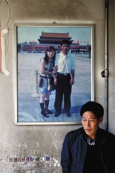 11月14日，承德市平泉縣，潘小梅父母的家，潘小梅父親靠在墻上，身后掛著數(shù)年前他和潘小梅在北京的合影照片。新京報(bào)記者