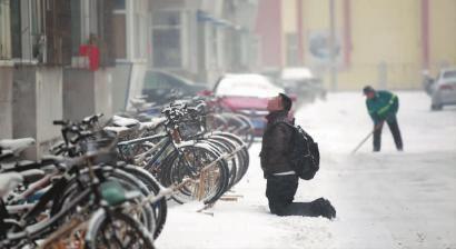 小伙子跪在樓前，一直抬頭看著樓上。 孫立國(guó)/攝